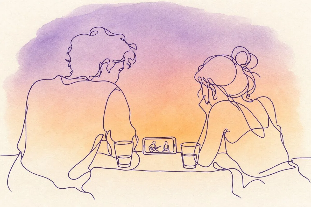 A rooftop at night with two drinks on a ledge and a phone between them playing, a city far below